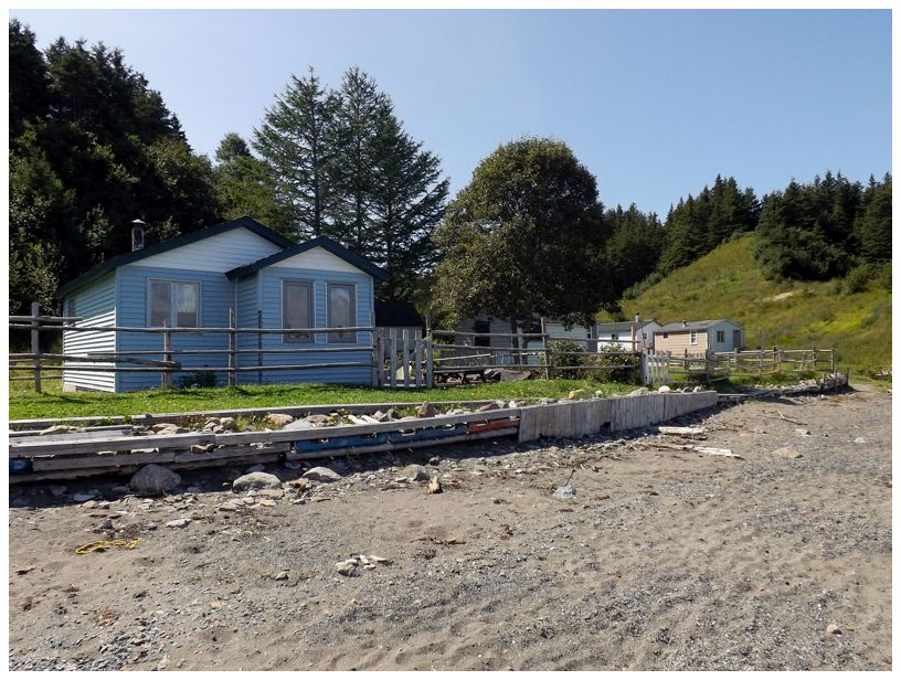 houses in brakes cove, blue house in the front, sandy beach